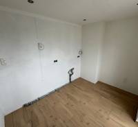 Unfurnished room in a 2-room apartment, light walls, wooden floor.