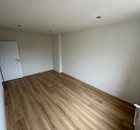 A spacious room with laminate flooring and white walls in a 2-room apartment.