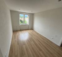 An empty room with a wooden floor and a window in a two-room apartment.