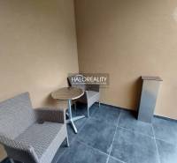 Balcony of a 1-room apartment with rattan chairs and a table, suitable for relaxation.