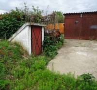 A family house in Leh with a neglected garden and a small metal tool shed.