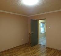 The interior of a room with brown walls and wooden flooring in a family house.
