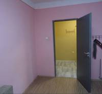 The interior of a family house with pink walls and open doors to another room.