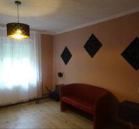 Living room of a family house with a red sofa and curtains on the window.