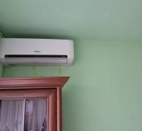 Air conditioning placed above the cabinet and a green wall in a studio apartment.