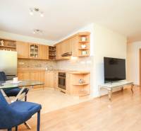 A bright kitchen with a table and chairs in a 2-room apartment with a television.