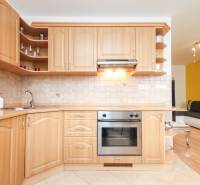 A kitchen in a 2-room apartment with a wooden cabinet and built-in appliances.