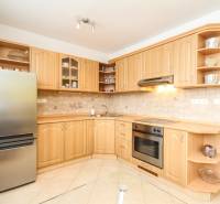 A kitchen in a 2-room apartment with a wooden cabinet and built-in appliances.
