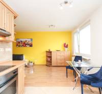 A kitchen with a dining table and chairs in a yellow two-room apartment.