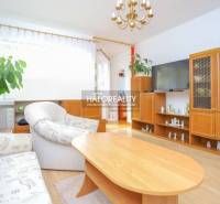Living room of a three-room apartment with wooden furniture and comfortable seating.