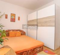 Bedroom in a 3-room apartment with an orange bed and a large wardrobe.
