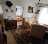 Living room in a 3-room apartment with a sofa, table, and decorative carpet.