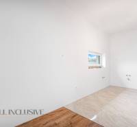 Cozy room with white walls and a small window in a family house.