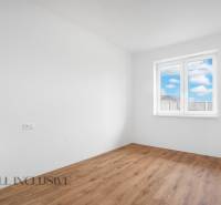 An empty room with a wooden floor in a family house, large window with a view.