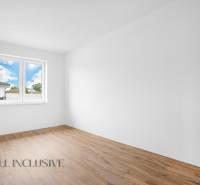 An empty room in a family house with white walls and wooden floor.