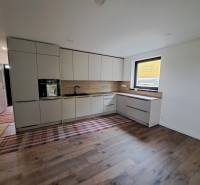 A kitchen in a family house with built-in cabinets and a beautiful wooden floor.