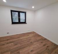 An empty room with a wooden floor and a window in a family house.