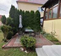 Rodinný dom Mošovce, Turčianske Teplice: terasa so záhradným nábytkom a tujami v záhrade.