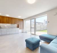 Living room in a family house with light and a kitchen in the background.