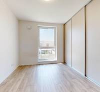 A room in a family house with a wooden floor and a built-in wardrobe, natural light.