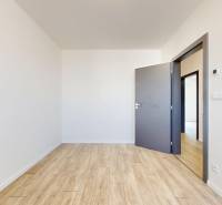A room in a family house with a wooden floor and open doors.