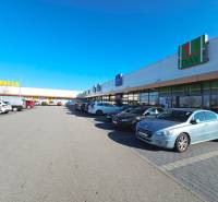 Parking lot with cars, shops, Billa, blue sky, location on Repíková street in Bratislava.