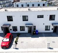 Family houses on Obchodná Street in Hviezdoslavov with a parking lot and surrounding buildings.