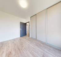 A room in a family house with laminate flooring and a built-in wardrobe.