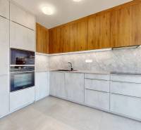 A kitchen in a family house with built-in appliances and wooden cabinets.
