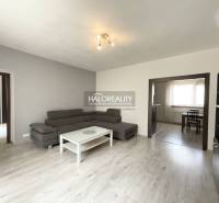 Living room in a family house with a gray sofa and a white table.