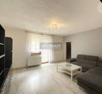 Living room in a family house with a sofa, coffee table, and shelving unit.