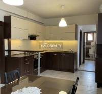 A kitchen unit with a dining table in a family house, including bright lighting and tiles.