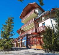 A building with wooden balconies surrounded by trees on Donovaly Street in Donovaly.