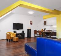 A bright interior of a 2-room apartment with yellow elements, a kitchen, and a seating area.
