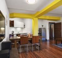 Living room in a two-room apartment with wooden furniture and yellow columns.