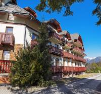 Exterior of a 2-bedroom apartment in Donovaly with balconies and a mountain backdrop.