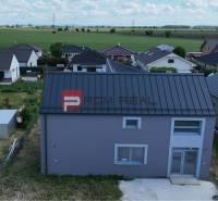 A family house in Cífer, gray facade, surrounding houses and fields in the background.