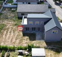 A family house in Cífer with a garden and an adjacent road in a residential area.
