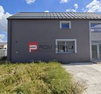 A family house in Cífer with a grassy plot and an asphalt access road.