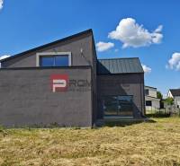 A family house in Cífer surrounded by other houses and a blue sky.