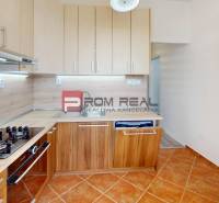 Kitchen in a 2-room apartment, light cabinetry, gas stove, brown tiles, built-in appliances.