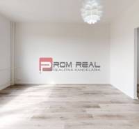 Spacious living room in a 2-room apartment with large windows and light floors.