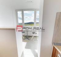 A kitchen in a 2-room apartment with a view of natural scenery.