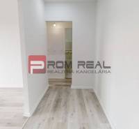 A hallway and light floor in a 2-room apartment with white walls.