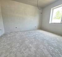 An unfinished room with a window in a family house waiting for interior completion.