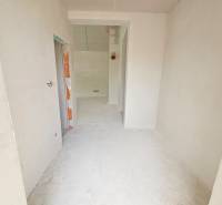 A construction site with gray walls and a floor in a family house.