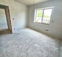 Empty room in a family house with unfinished walls and a concrete floor.