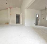 A view of an unfinished interior in a family house with white walls and floor.
