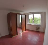 A room with large windows and a wardrobe in a 2-room apartment.