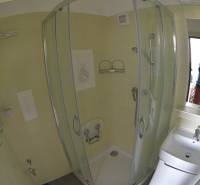 A bathroom with tiles and a shower in a 2-room apartment.